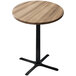 A round wooden Holland Bar Stool outdoor table with a black cross base.
