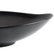 A close up of a black Reserve by Libbey Pebblebrook bowl with a curved edge.