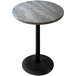 A round grey stone table top with a black base on a round pole.