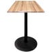 A Holland Bar Stool natural wood table with a black base.