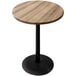 A round wooden Holland Bar Stool outdoor bar table with a black base.