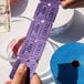 A pair of hands holding purple Carnival King raffle tickets.