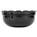 A black fluted bowl with scalloped edges.