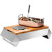 A stainless steel Rosseto Multi-Chef chafer alternative warmer base with food inside on a wood surface.