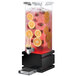 A Rosseto clear plastic beverage dispenser with black accents and fruit inside.