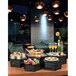 A table with Rosseto black matte hexagon risers holding food and drinks.