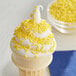 An ice cream cone with Yellow Sprinkles.