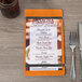 A Menu Solutions wood menu board on a table.
