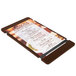 A Menu Solutions walnut wood menu board with rubber band straps holding a menu.