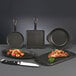 A group of Libbey mini cast iron square skillets with meat and vegetables cooking inside one.