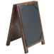A walnut wood table tent with picture corners on a table with a black board.