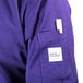 A person wearing a Mercer Culinary purple cook jacket.