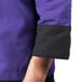 A Mercer Culinary Millennia purple chef jacket with black sleeves and purple trim.