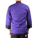 A man wearing a purple Mercer Culinary chef jacket with black details.