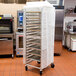 A white Curtron bun pan rack cover on a large rack.
