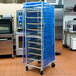 A Curtron blue breathable mesh cover on a bun pan rack.