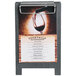A Menu Solutions ash wood sandwich menu board tent with a clip on a table displaying a menu.