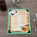 A Menu Solutions Washed Teal wood menu board on a table with a menu and a fork.