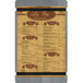 A Menu Solutions wood menu board with brown rubber band straps.
