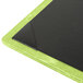 A Menu Solutions lime green and black wood menu board on a table.