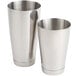 Two stainless steel cocktail shakers, one silver cylinder and one silver cup.