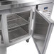 A Traulsen stainless steel refrigerated pizza prep table with open doors on a counter.