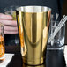A close-up of a gold-plated Barfly cocktail shaker tin.