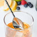 A Barfly stainless steel Japanese style bar spoon in a glass of liquid with berries.