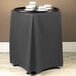 A black table with a Snap Drape charcoal table stand cover on it.