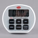 A white digital timer with a digital clock display and black buttons.
