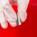 A hand in white gloves holding an Ateco open star piping tip.