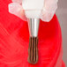 A person using an Ateco closed star piping tip on a pastry bag.