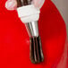 A person's hand using an Ateco closed star piping tip and pastry bag to pipe chocolate frosting on a cake.