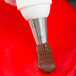 A close up of an Ateco Drop Flower Piping Tip on a pastry bag.