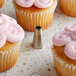 A cupcake with pink frosting piped using an Ateco Open Star piping tip.