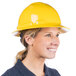 A woman wearing a yellow Cordova full-brim hard hat with a ratchet suspension smiling.