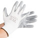 A pair of white Cordova gloves with gray flat nitrile coating on the palm.