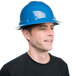 A man wearing a Cordova blue full-brim hard hat with 4-point ratchet suspension.