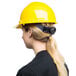 A woman wearing a yellow Cordova hard hat with a ponytail.