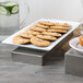 A Tablecraft stainless steel rectangular bowl on a table with cookies.