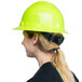 A woman wearing a green Cordova full-brim hard hat with a ponytail.