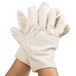 A pair of large white cotton work gloves with red double palm lines.