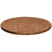 A brown circular Tablecraft aluminum table cover with a random swirl pattern on a table.