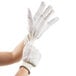 A pair of white Cordova double palm work gloves with red stripes.
