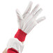 A hand wearing white gloves with red stripes.