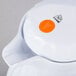 A white Vollrath SwirlServe beverage server with an orange circle on the lid.