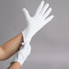 A person wearing Cordova heavy weight white inspection gloves.