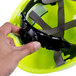 A hand holding a green Cordova Duo safety helmet with black straps.