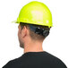 A man wearing a green Cordova Duo cap style hard hat and safety vest.