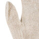 A close up of a beige knit Cordova work glove with a thumb.